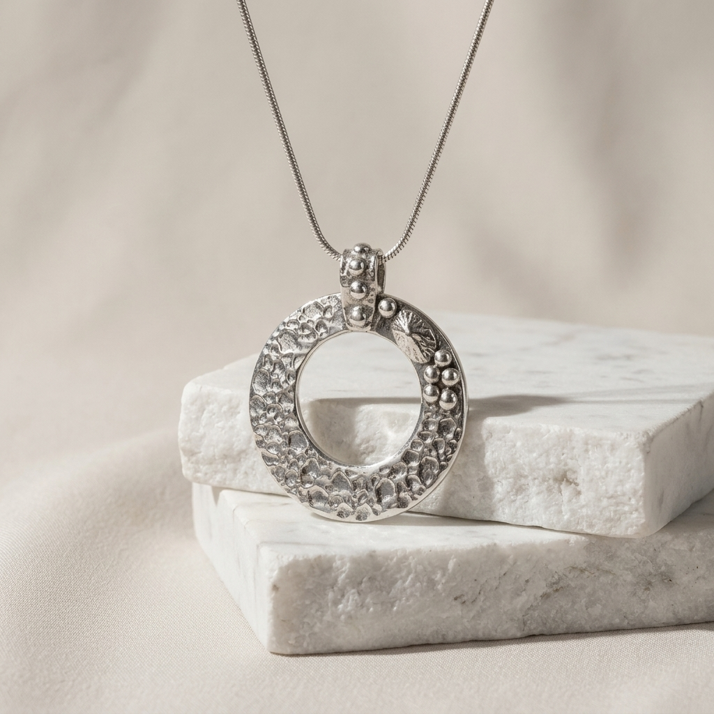 Silver circular pendant with a shell and bubbles